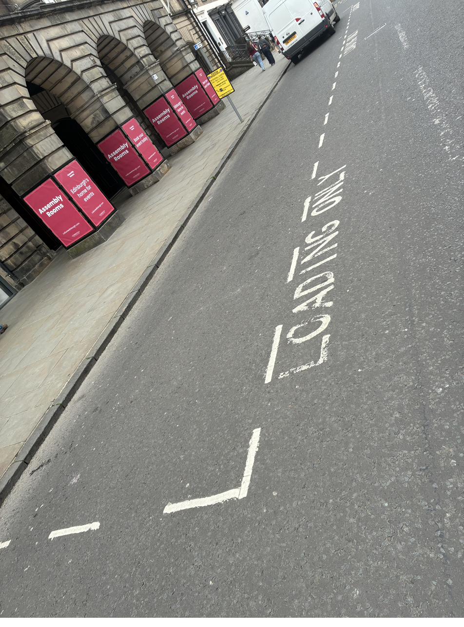 Edinburgh loading only bay road marking with white text on George Street outside the Assembly Rooms